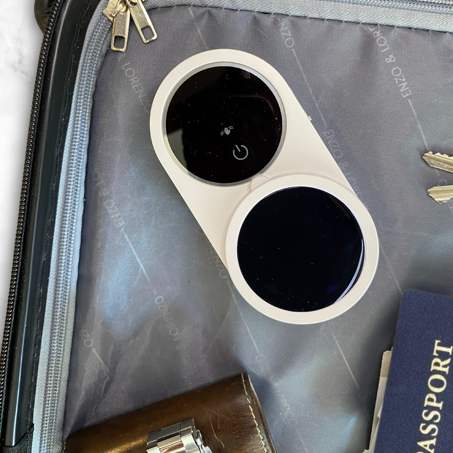 PureVee UV toothbrush sanitizer in baggage with passport, keys, watch, and wallet, perfect for travel.